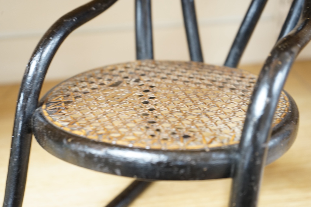 A miniature black bentwood rocking chair with cane seat, possibly made as an apprentice piece, 8cm high at the back, rockers 33cm long. Condition - some scuffing to frame, seat good.